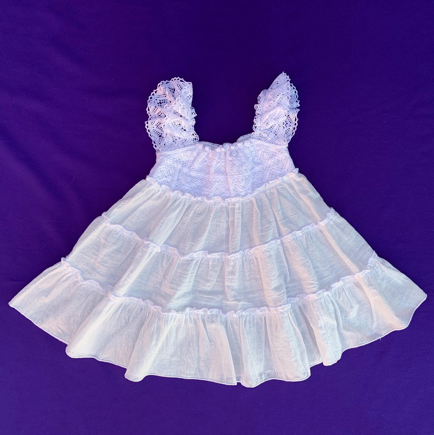 Detalle del vestido de puntillas de algodón para niñas y bebés de Tizor Ibiza. Moda infantil sostenible.
